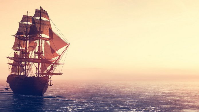 Pirate ship sailing on the ocean at sunset statek